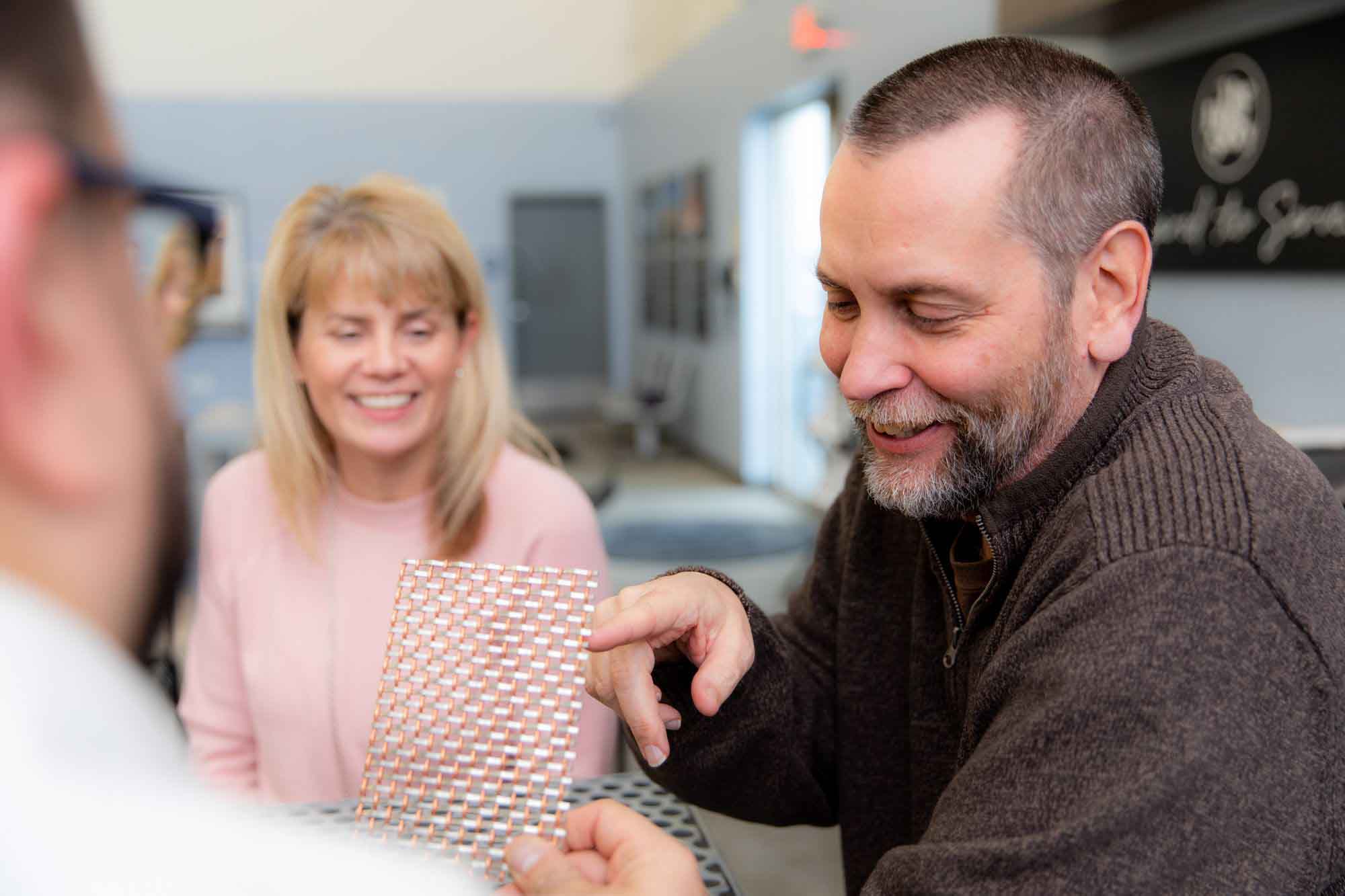 A customer taking a look at a sample with sales associates.