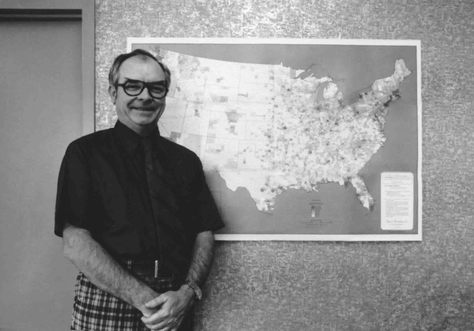 Bob McNichols standing next to a map of the United States.