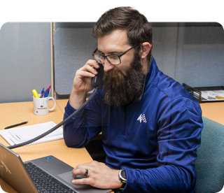 A McNICHOLS® Customer Service Specialist at a desk, taking a phone call.