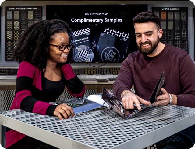 Two McNICHOLS® Customer Service Specialists reading through a quad mailer and discussing samples.